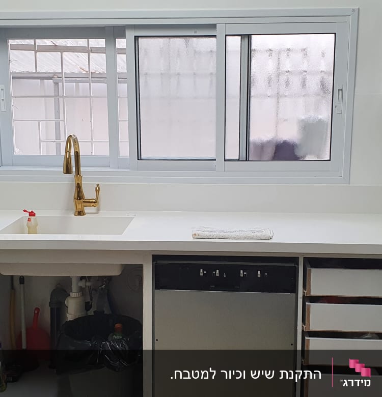 מטבח עם משטח שיש לבן וכיור מובנה